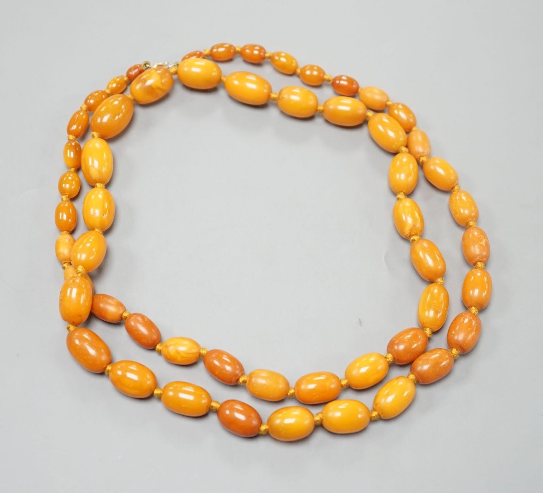 A single strand graduated oval amber bead necklace, 88cm, gross weight 50 grams.